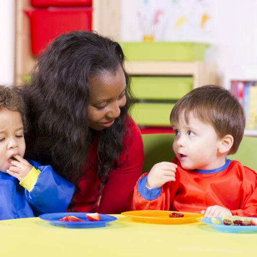 Teacher watching two boys eat.