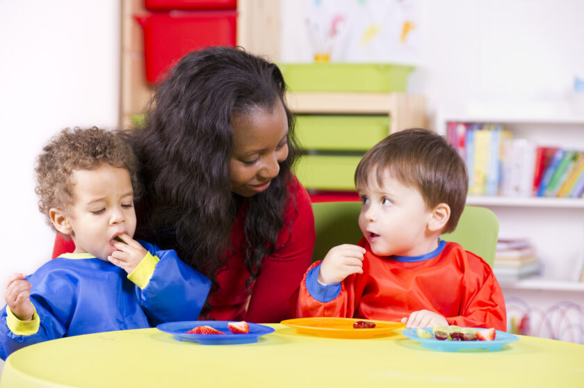 Teacher watching two boys eat.