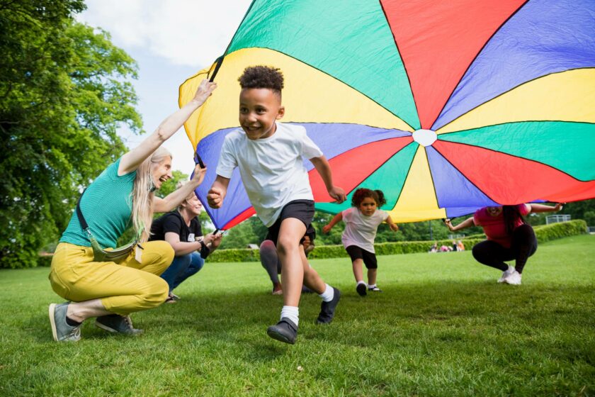 Kids playing under parachute.